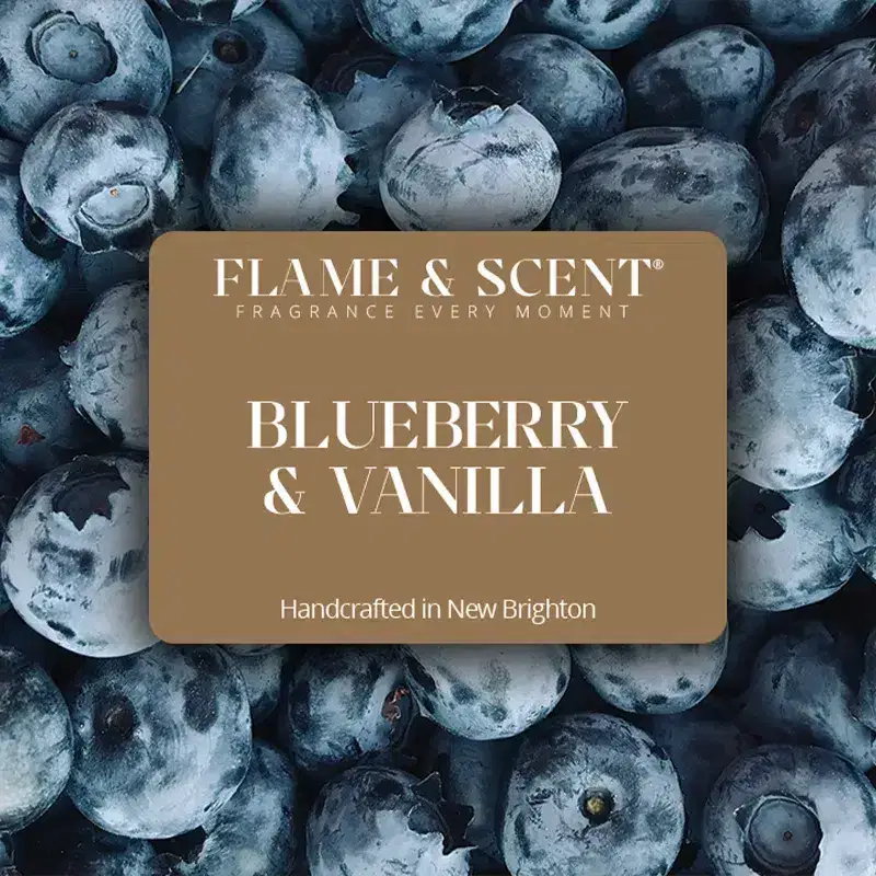 BV Flame & Scent A label reading FLAME & SCENT BLUEBERRY & VANILLA Blueberry & Vanilla Candle Handcrafted in New Brighton is placed over a close-up background of fresh blueberries.