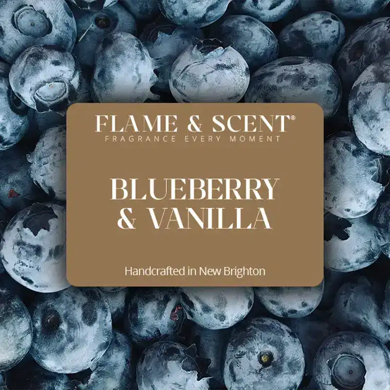 Flame & Scent A label reading FLAME & SCENT BLUEBERRY & VANILLA Blueberry & Vanilla Candle Handcrafted in New Brighton is placed over a close-up background of fresh blueberries.
