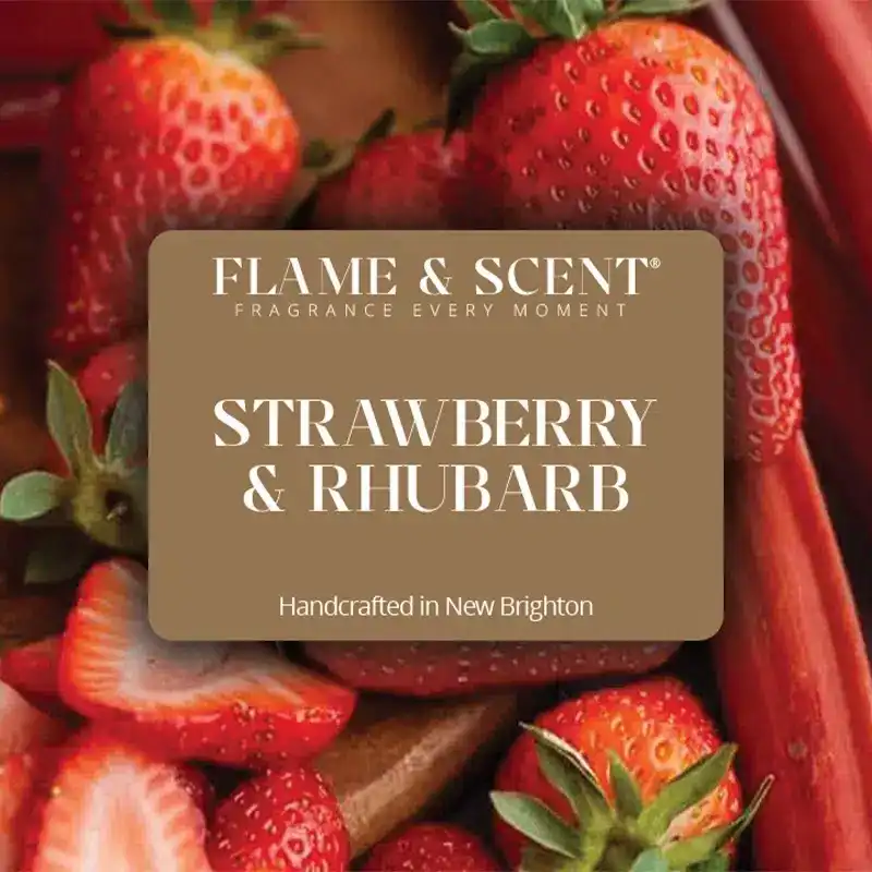 Flame & Scent A label reading Flame & Scent Fragrance Every Moment: Strawberry & Rhubarb Candle, Handcrafted in New Brighton, is set over fresh strawberries and rhubarb, capturing the essence of a strawberry & rhubarb candle.